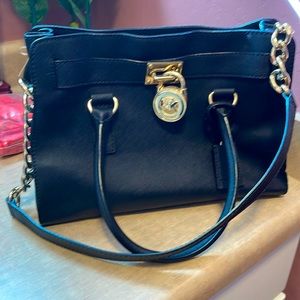 Michael Kors bag.  Black with gold chain, lock and key.